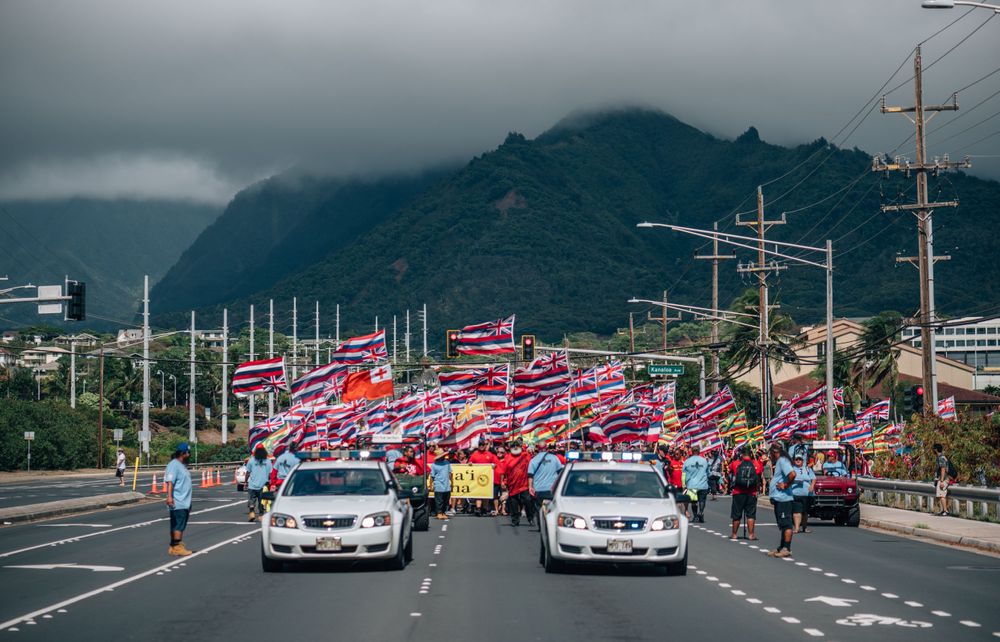 Police vehicles monitor a protest march along a mountain highway in Hawaii.