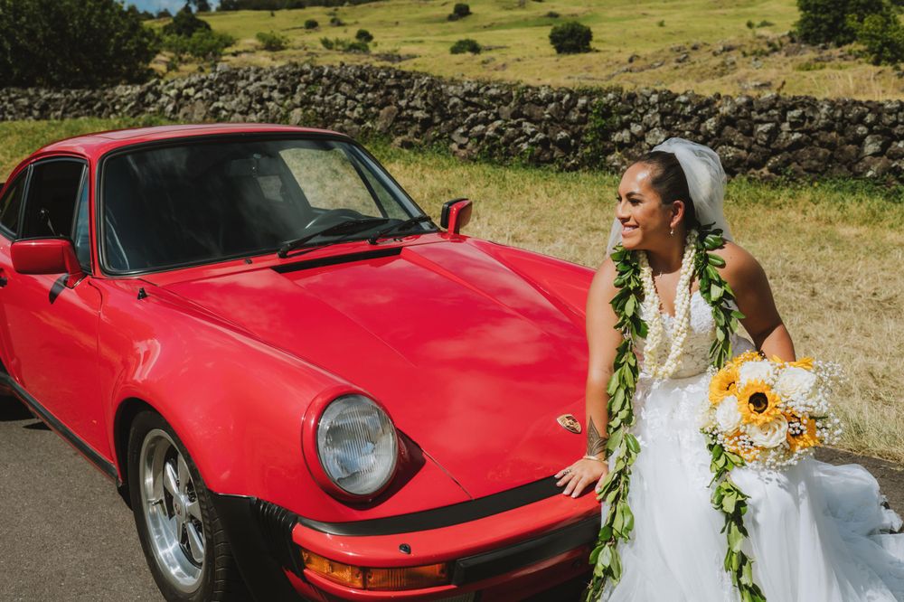 Red classic sports car featured in outdoor wedding photography session.