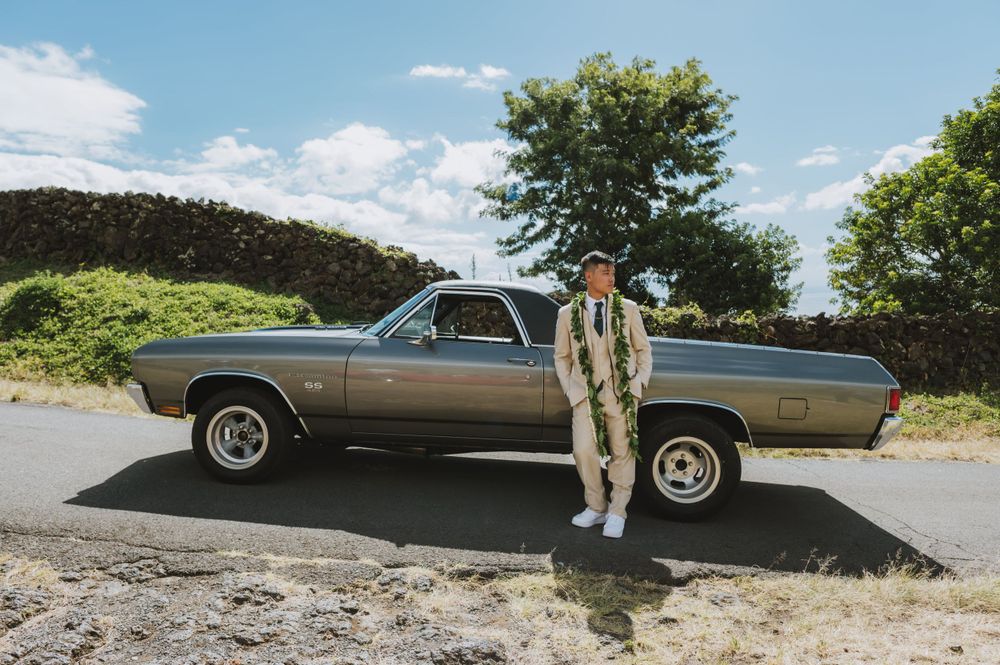 Vintage car photoshoot on a mountain road with scenic backdrop.