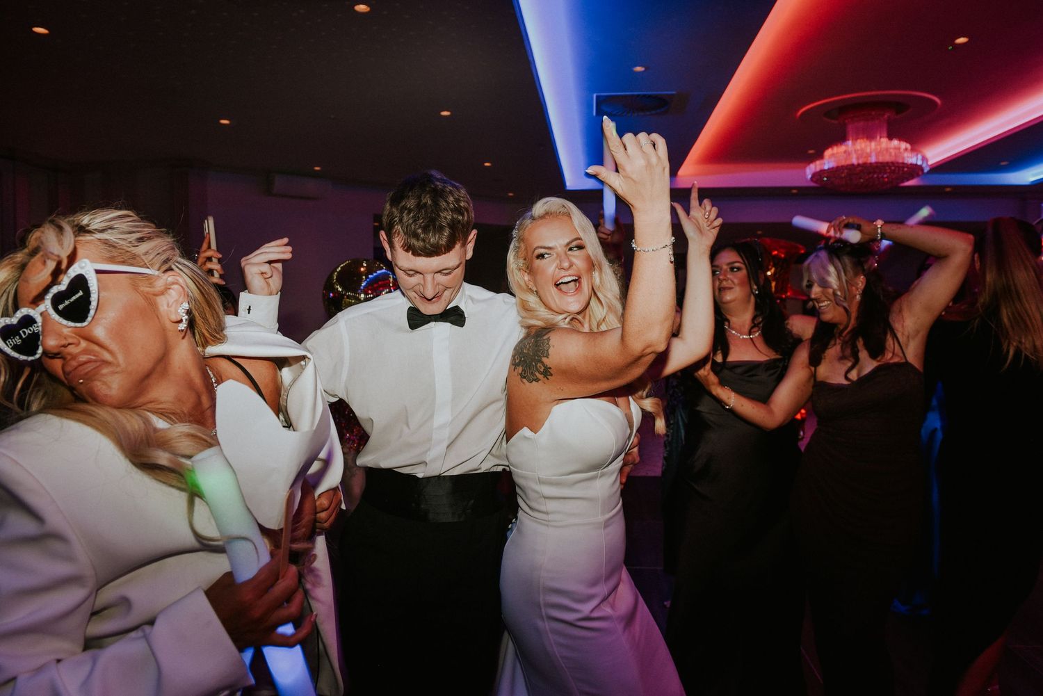 A Bride and Groom share a candid, joyful moment together in their wedding attire on a tree-lined path at Lochgreen Troon.