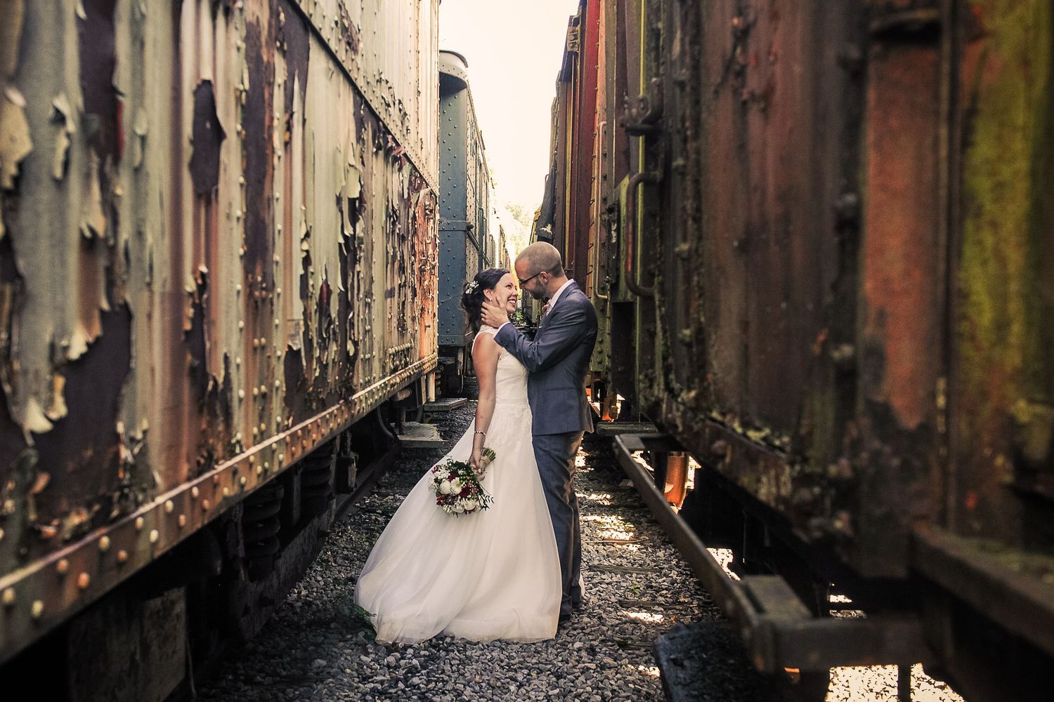 Couple de mariés posant dans une gare désaffectée pour un mariage original