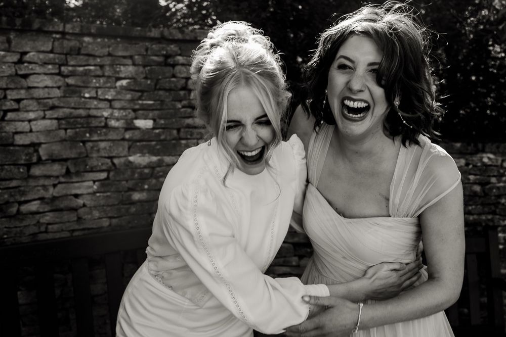 A series of candid black and white photos showing two people laughing and embracing against a brick wall.