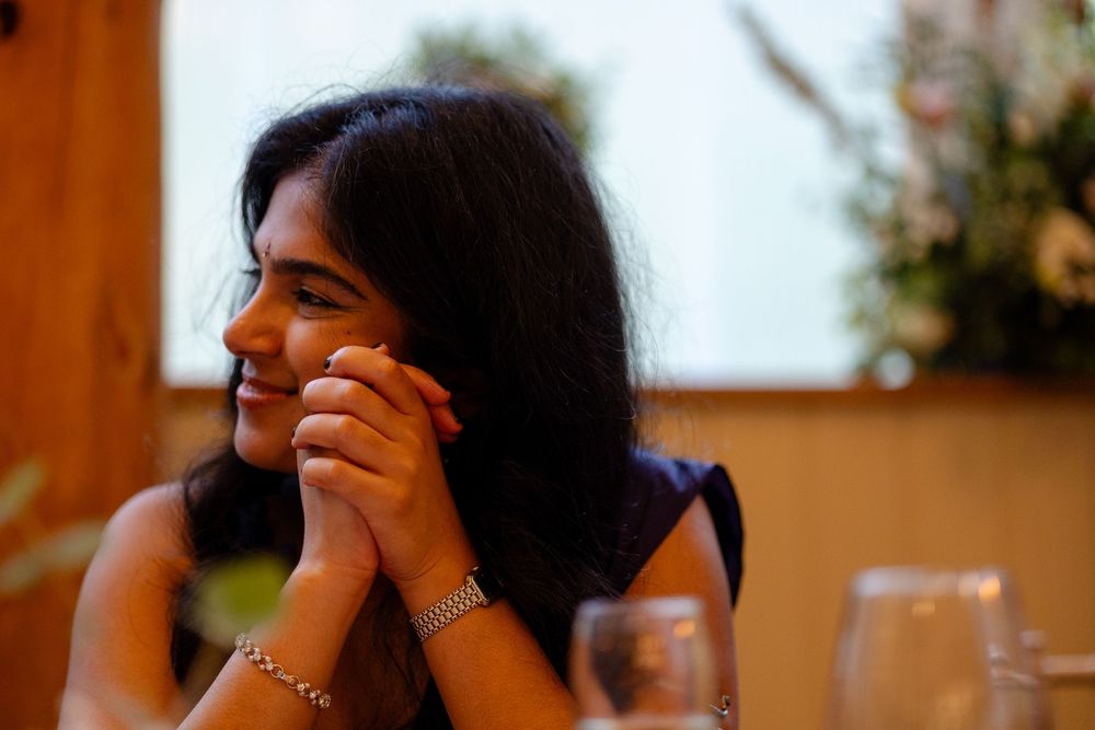 A series of six photos showing someone laughing and covering their face while sitting at a table.
