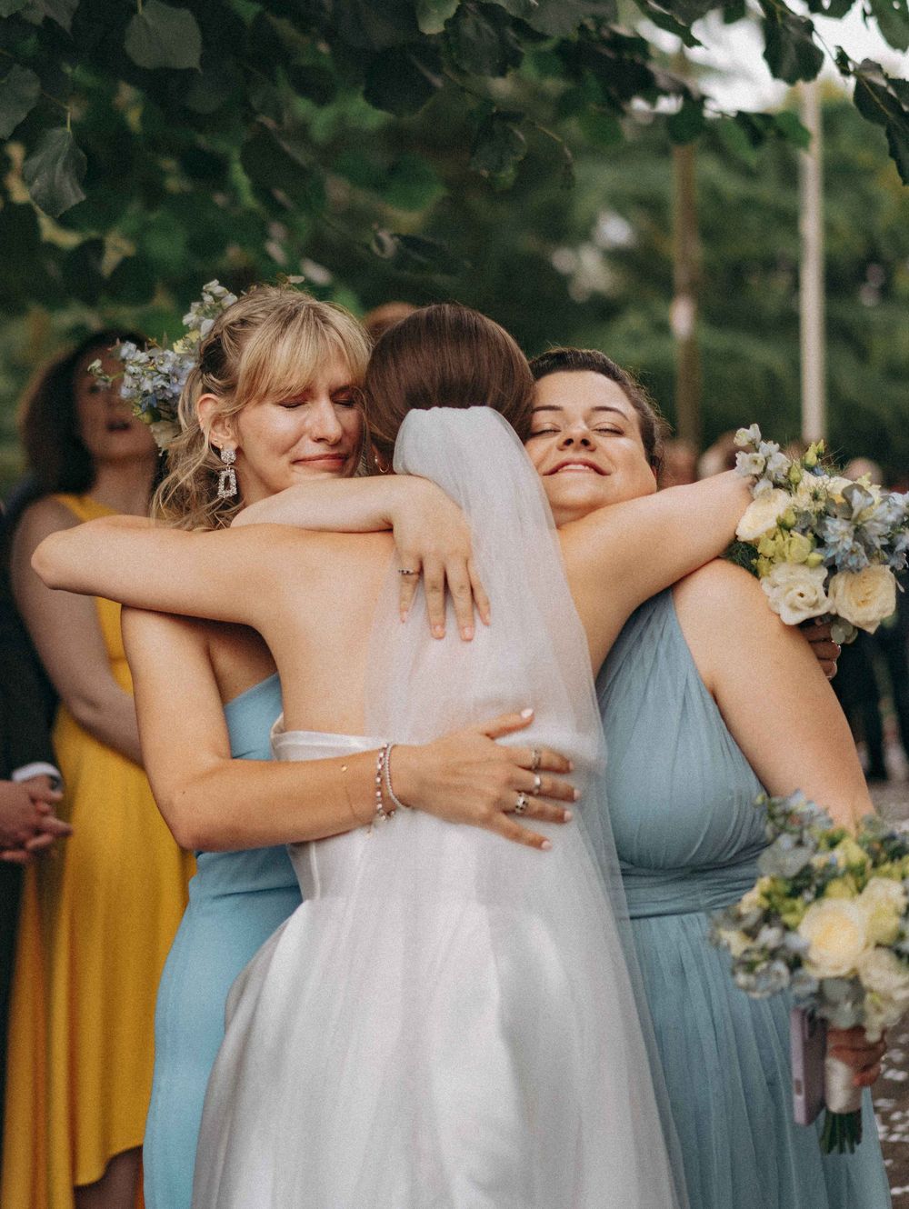 Bride sharing a hug with 2 teary eyed bridesmaids