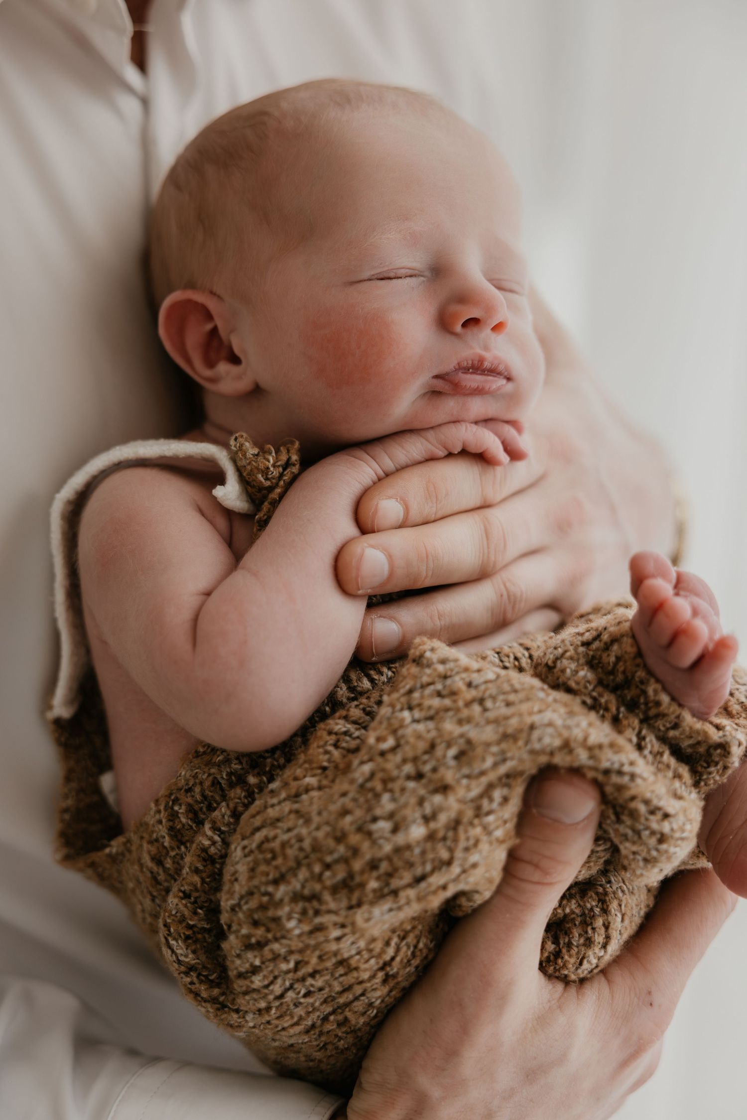 pasgeboren baby in de armen van de papa.