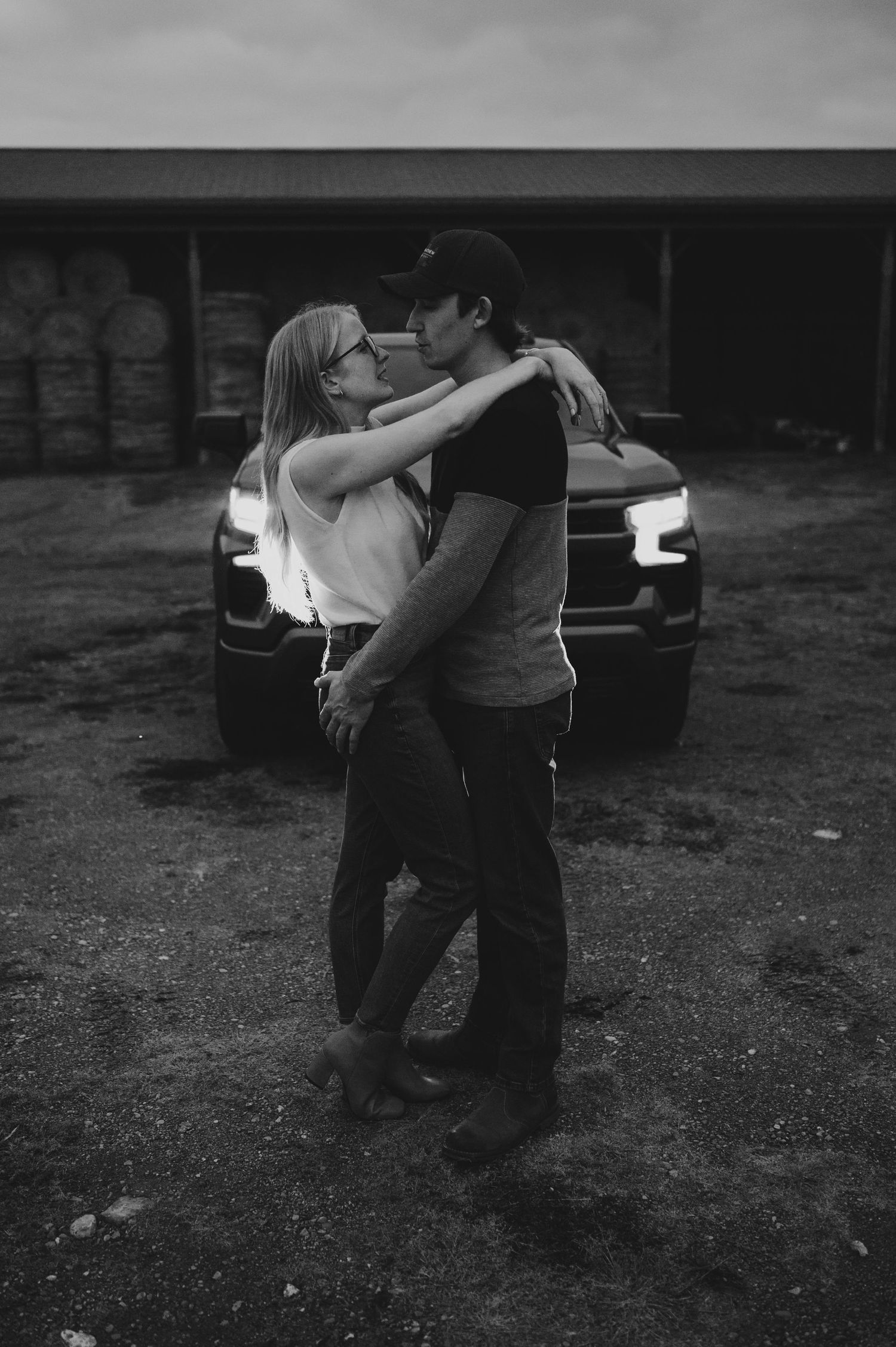Black and white photo series showing a couple dancing intimately in an outdoor setting at dusk.