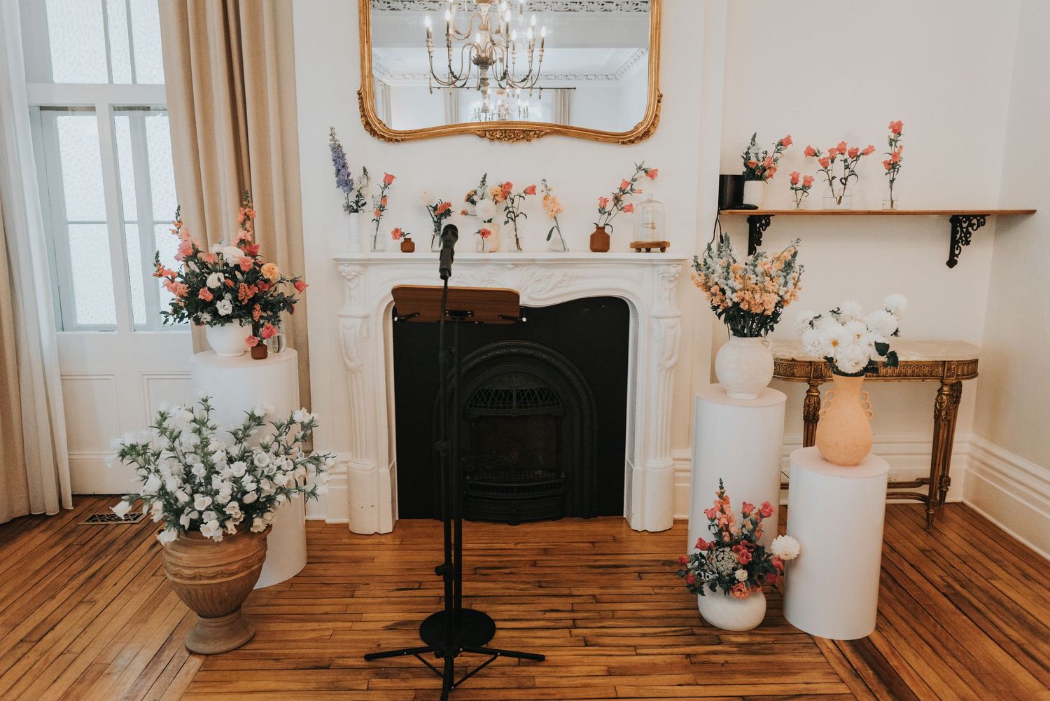 A bright and airy room interior with hardwood floors, white walls, and elegant vintage-style decor and lighting fixtures.