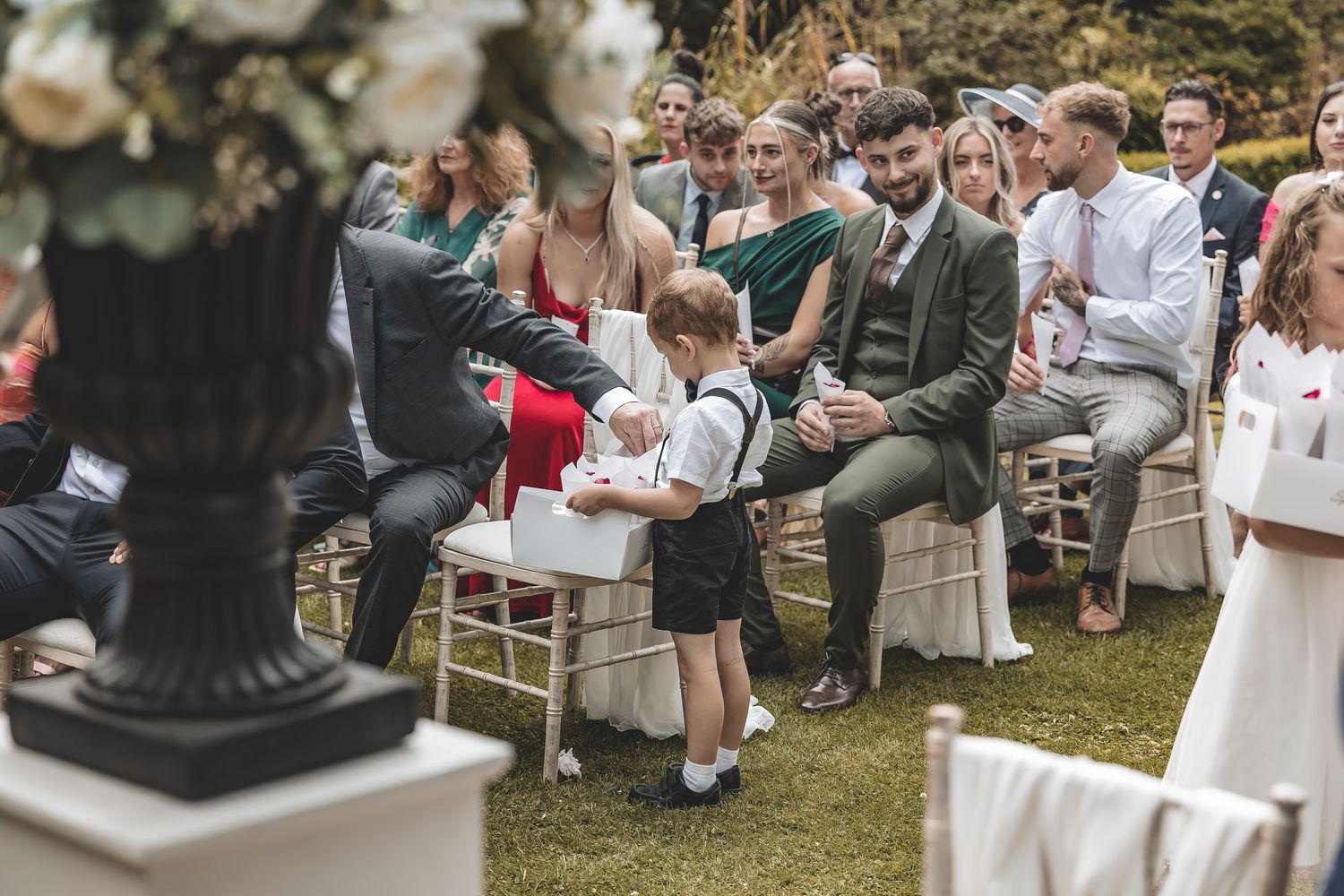 Emotional, natural moment page boy delivers confetti at a ceremony.