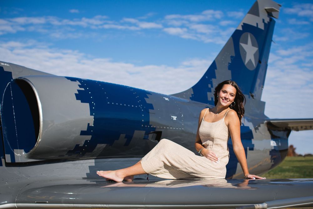 Modern editorial senior portrait with girl on jet plane in Howell Michigan; senior aviation photos by Brighton, MI photographer