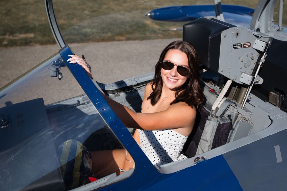 Modern editorial senior portrait with girl in jet plane in Howell Michigan; senior aviation photos by Brighton, MI photographer