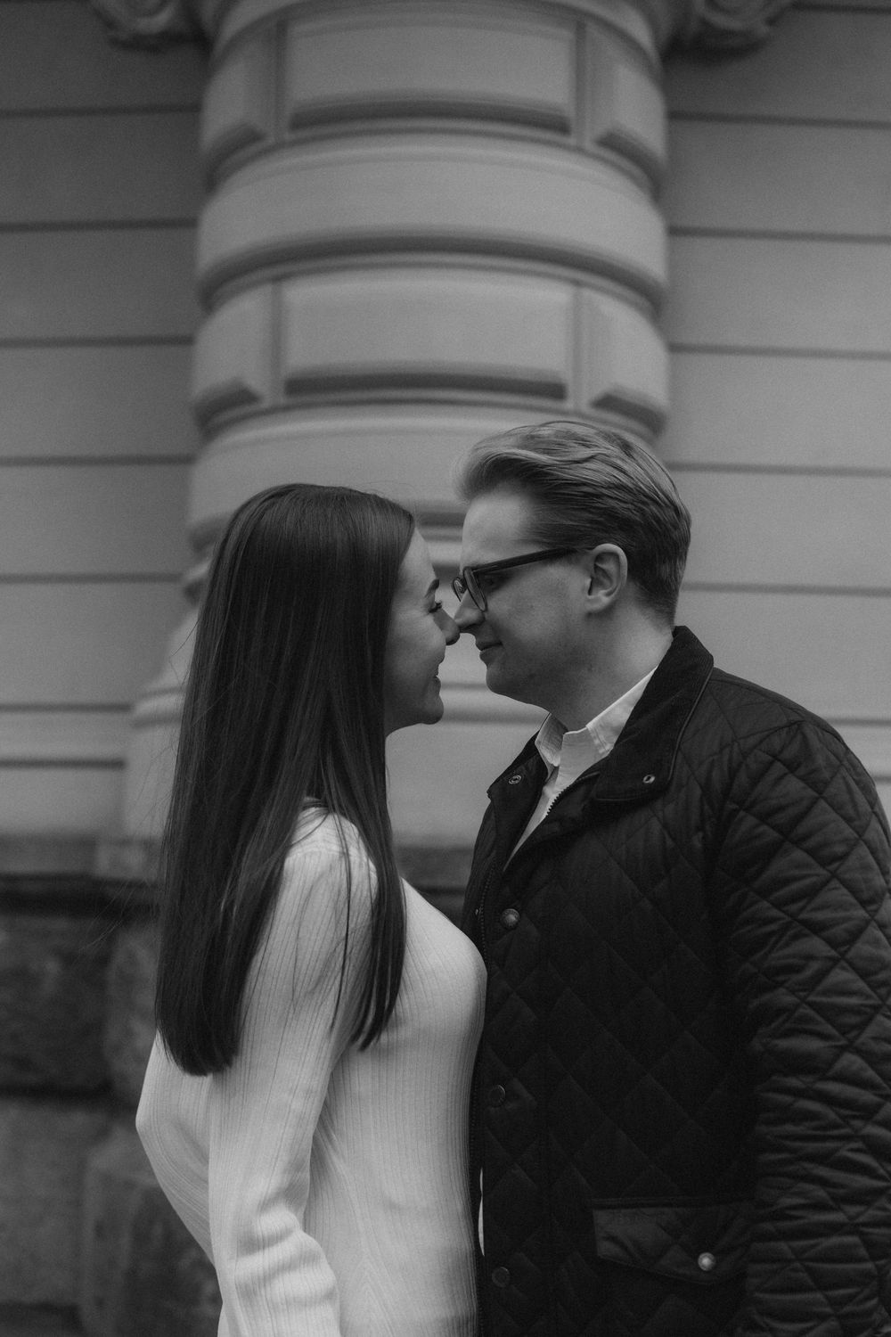 Stylish engaged couple standing together in dramatic city light during an engagement session in Helsinki