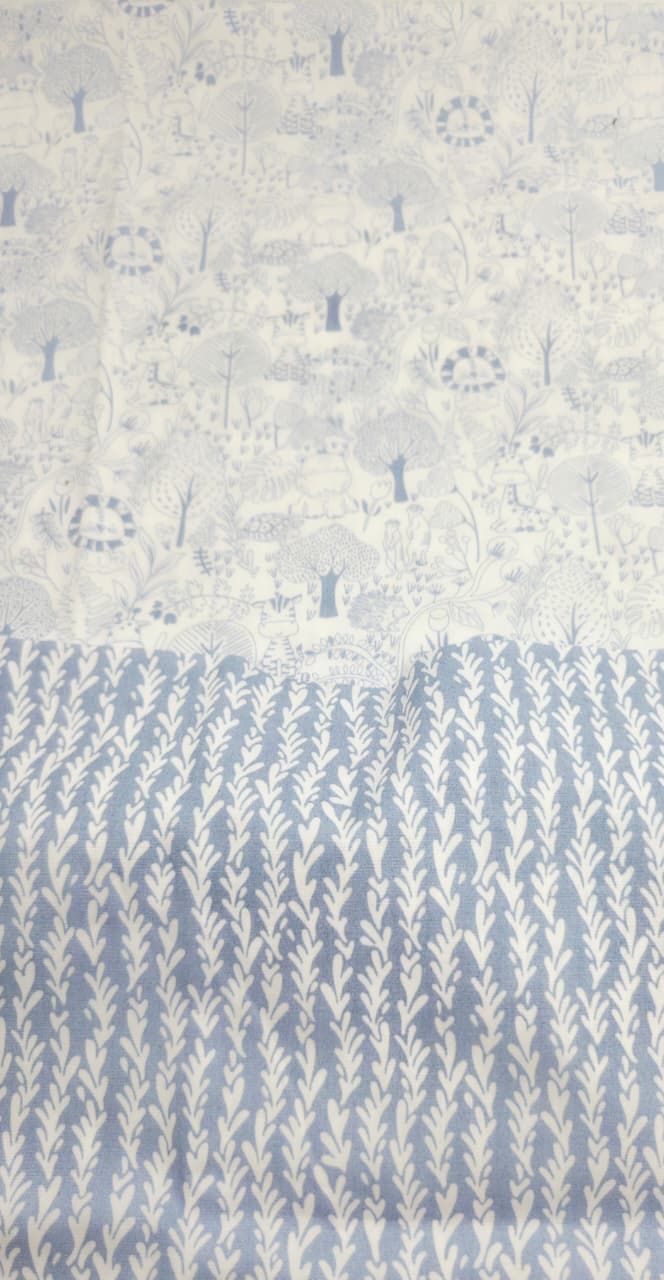 Blue and white fabric panel featuring a woodland scene on top and a leafy wheat pattern on the bottom half.