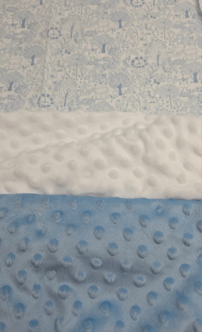 Three fabric swatches: blue woodland print cotton, white minky dot, and blue minky dot textile samples.