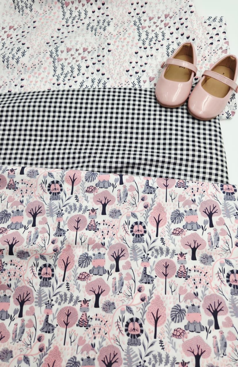 Pink mary jane shoes displayed on layered fabrics featuring gingham check, woodland animals, and floral prints in pink and white.