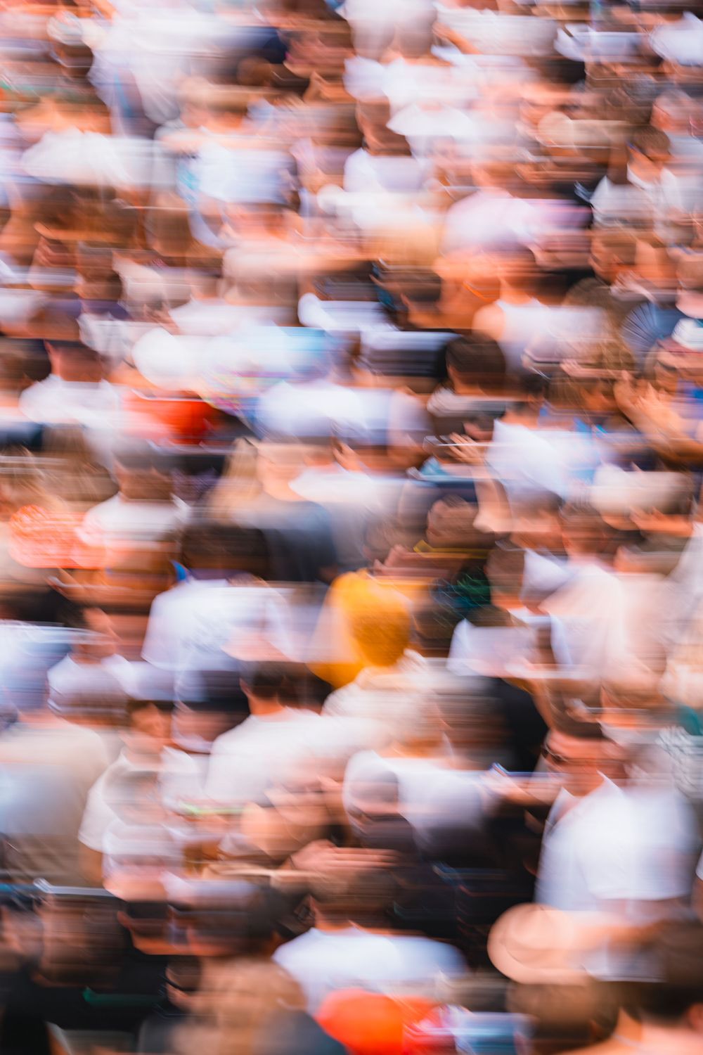 Blurred motion shot of a large crowd at an outdoor music festival.