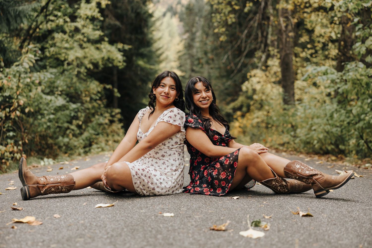 Candid lifestyle photo of people lying together on ground surrounded by autumn leaves.