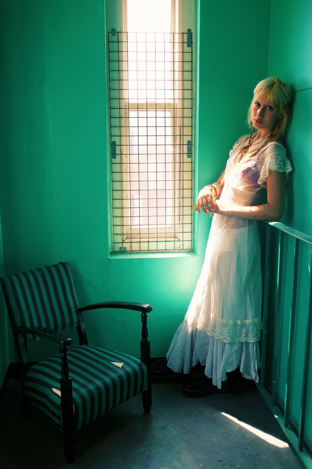 Dreamy portrait in turquoise room with vintage chair and window light.