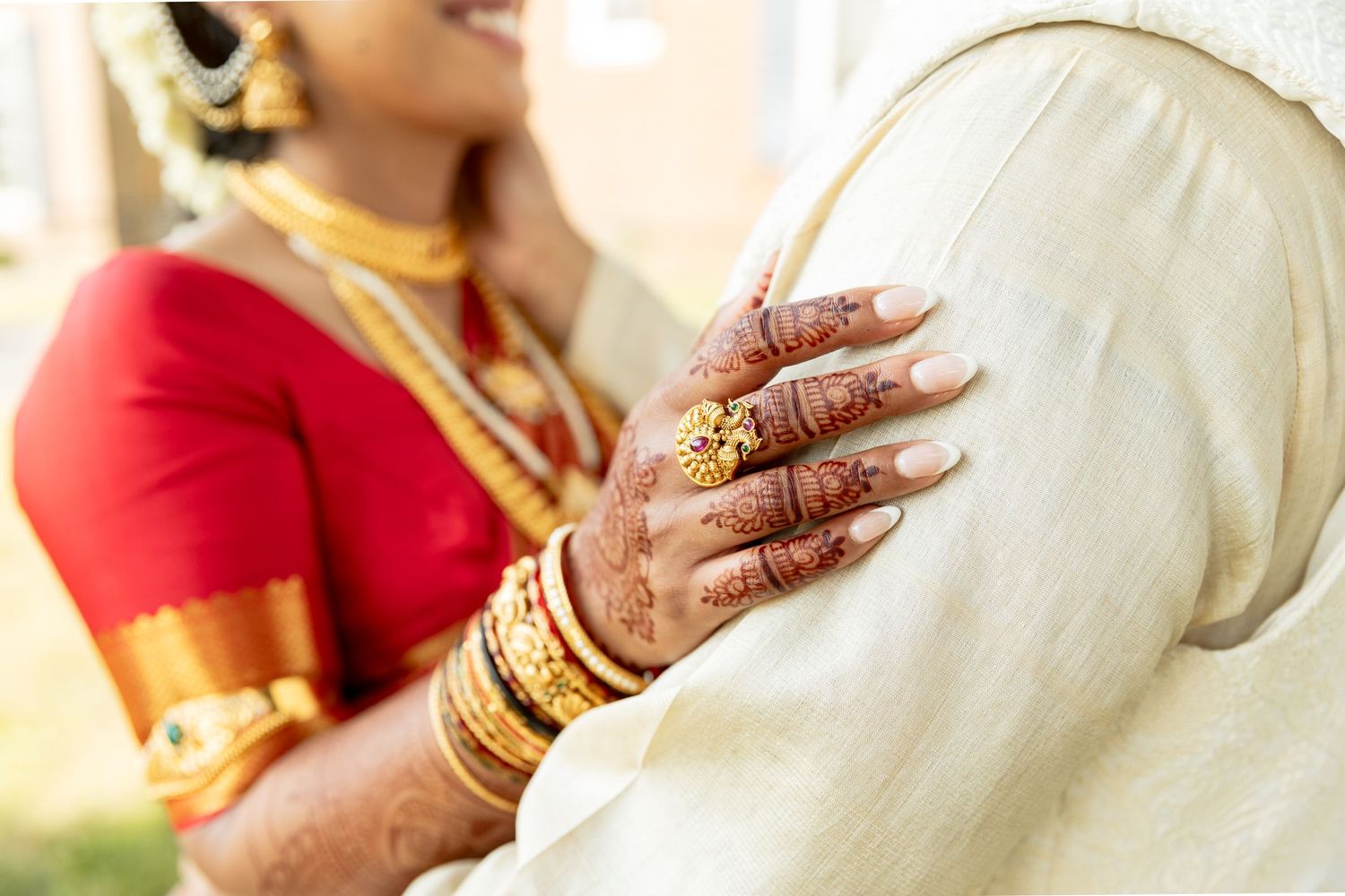 Close-up of traditional Indian wedding jewelry and henna adorned hands.