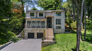 Aerial view of contemporary home nestled among mature trees.