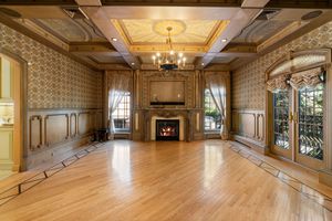 Spacious ballroom with ornate wooden ceiling details and large windows letting in natural light.