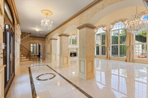 Grand interior space with curved archways and crystal chandeliers in an upscale residence.