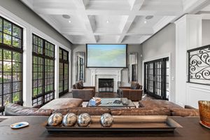 Modern living room with floor-to-ceiling windows and brown leather seating area.