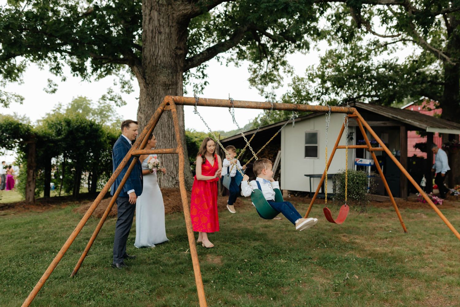 Wedding guests enjoying a playful moment on outdoor swings during reception.