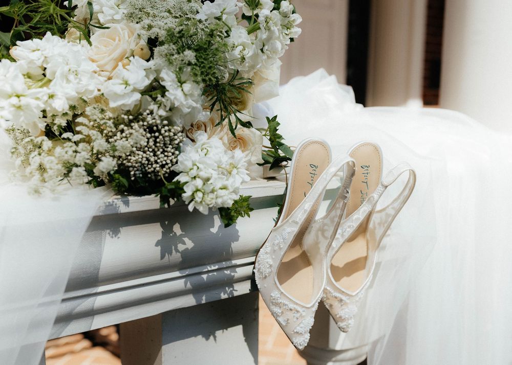 Wedding detail shot of white floral arrangements and delicate bridal accessories.