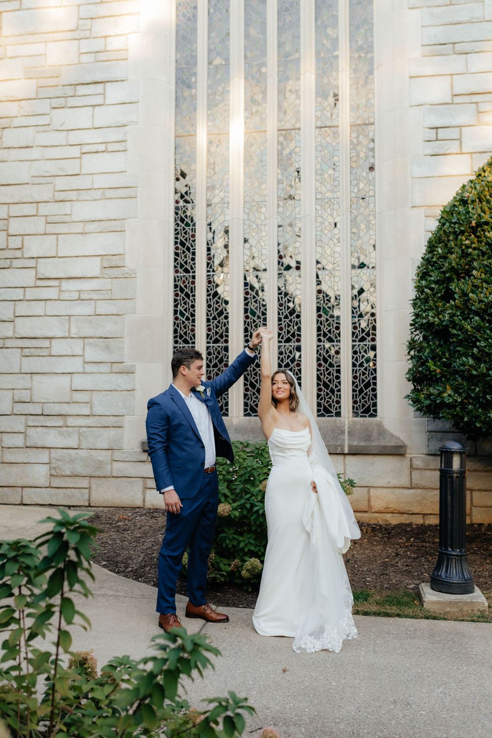 Elegant wedding photos captured against limestone church walls and landscaping.