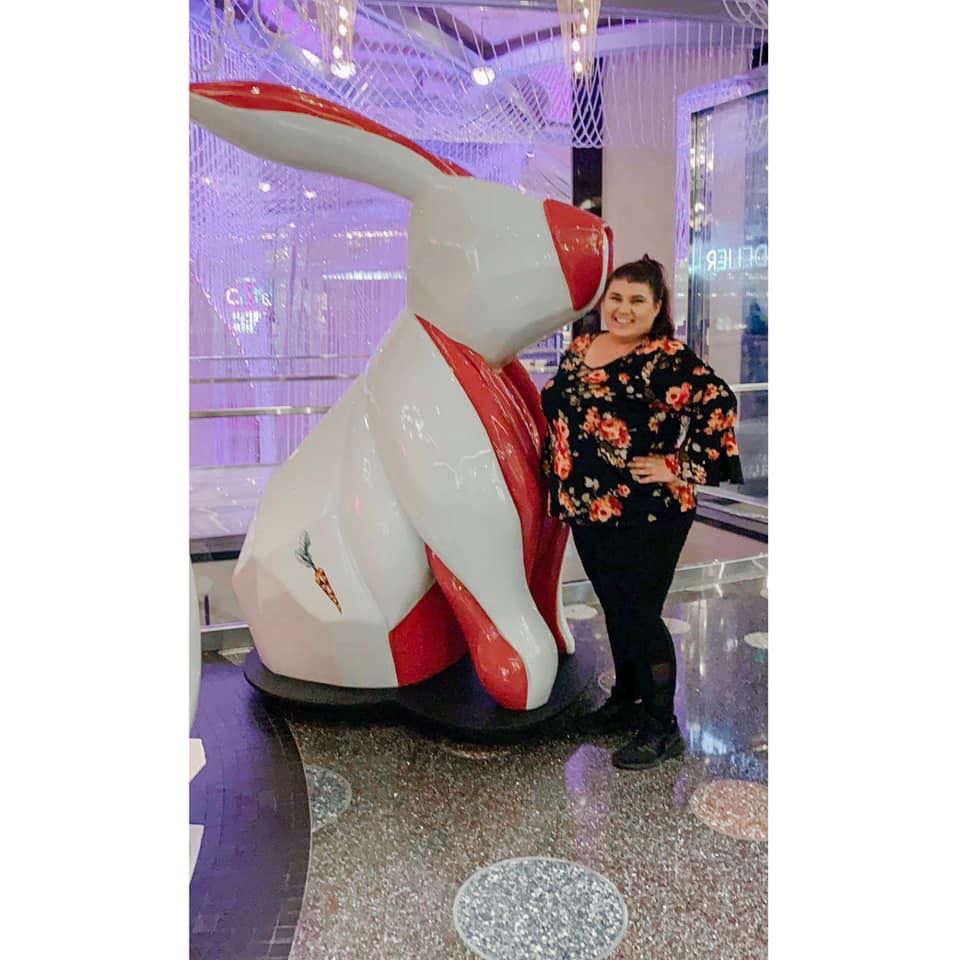 Colorful large bunny statue display in the cosmopolitan Las Vegas casino and hotel with purple lighting and reflective floor. plus size solo