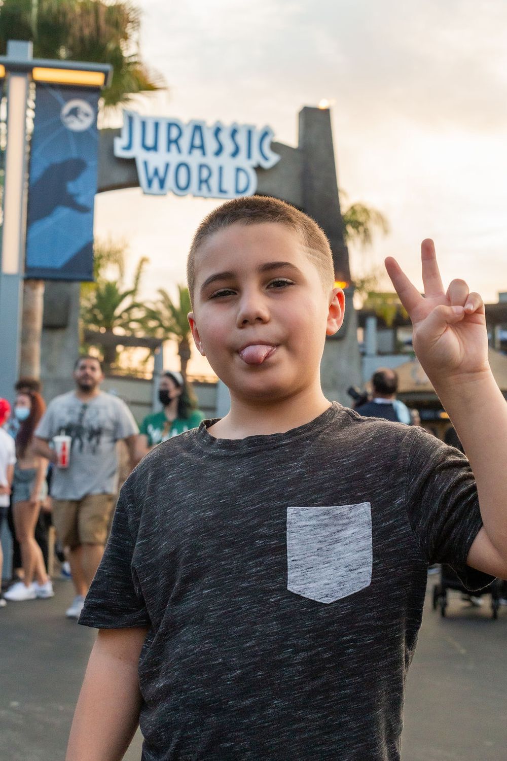 Boy at Jurassic World gate posing for photo at Universal Studios in California