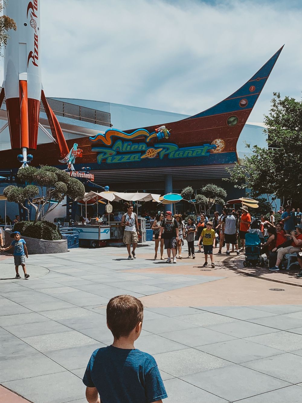 Outside Pizza Planet at Disneyland featuring themed decor, family fun, and classic Disney park photo moments.