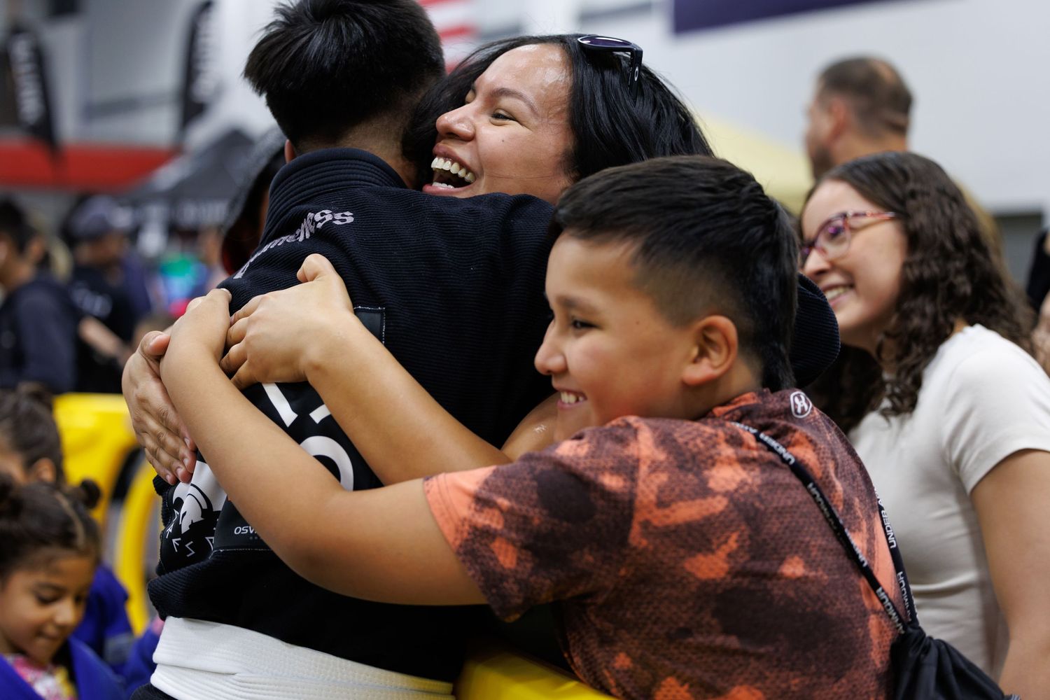 Athletes share emotional embraces after competing in a martial arts tournament.
