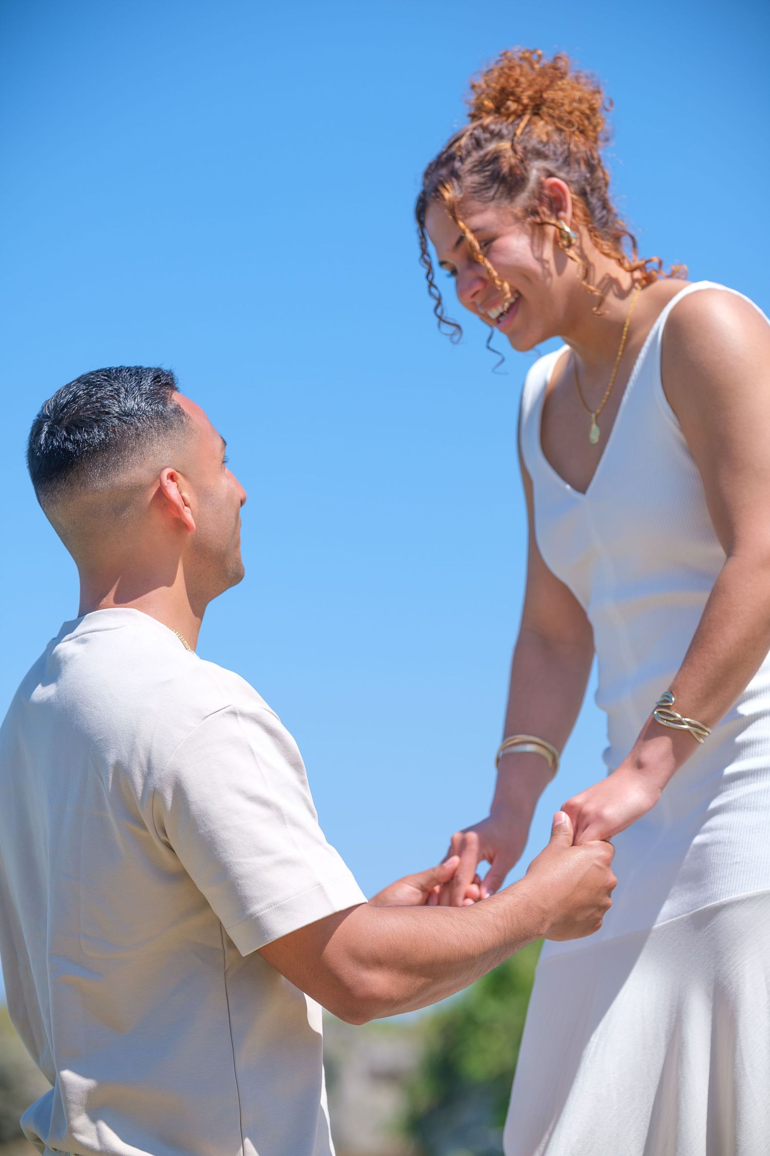 A special moment captured between a couple during what appears to be a proposal outdoors.