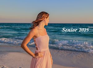 Side profile beach portrait at dusk showing a pink dress against dramatic ocean waves and golden light.