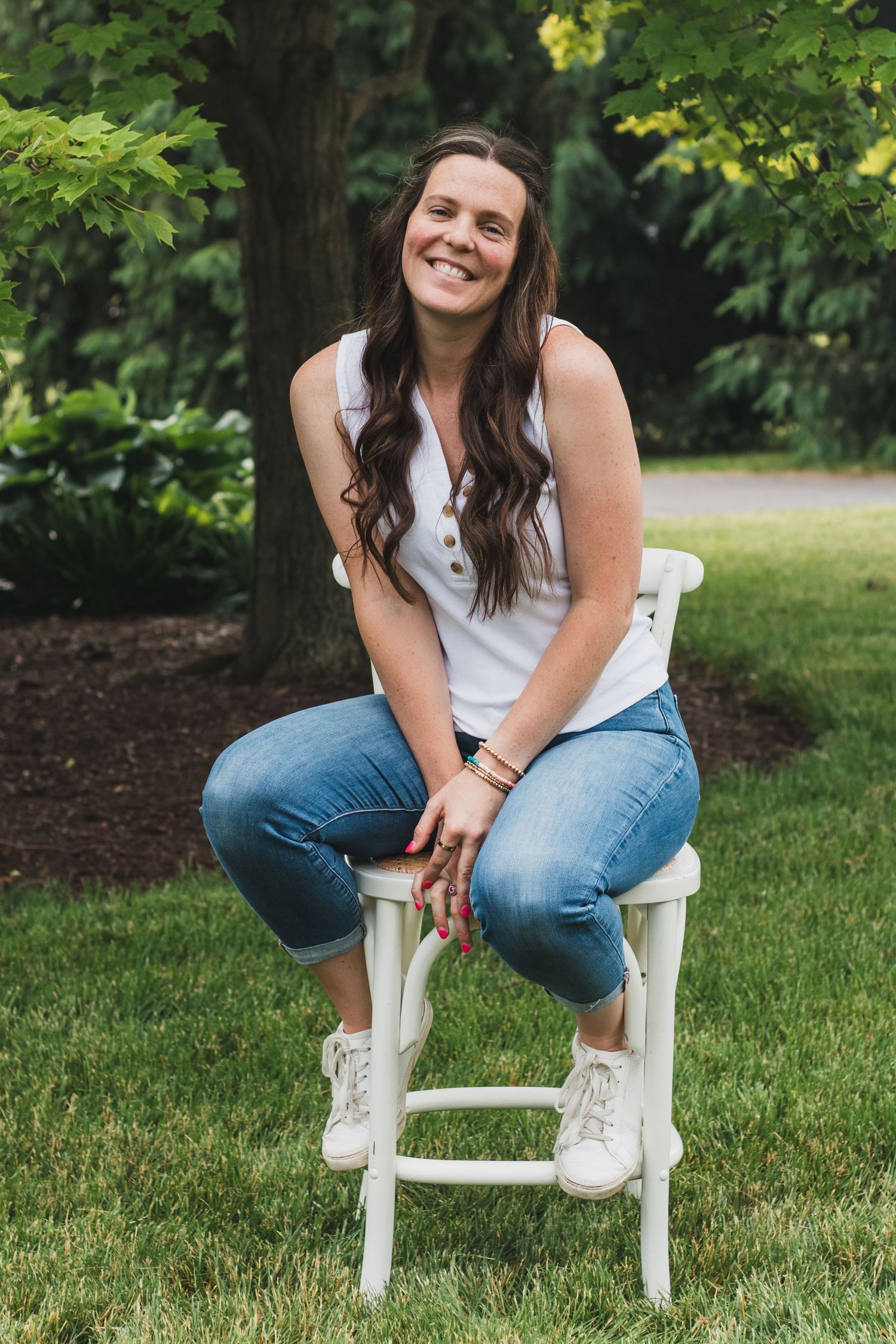 Woman sitting on a stool with a big smile. Self-portrait of Sam an affordable lifestyle family photographer in South Lyon, Michigan.