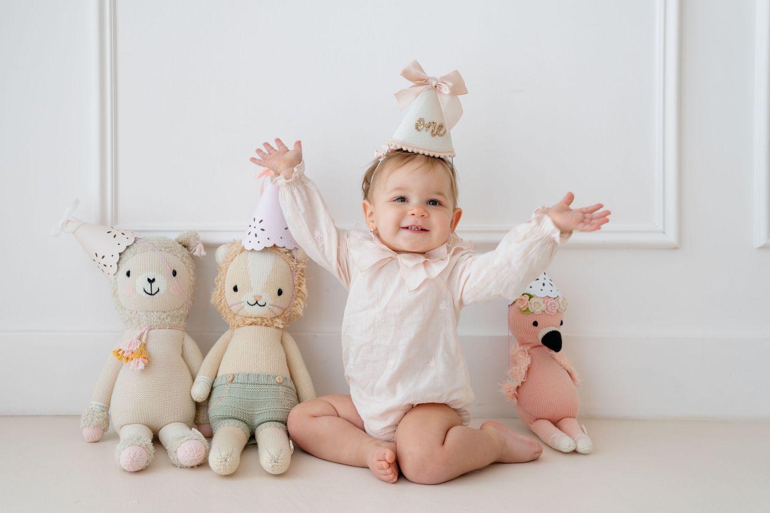 A sleeping newborn baby gently held up using a yellow cloth against a bright white window background.