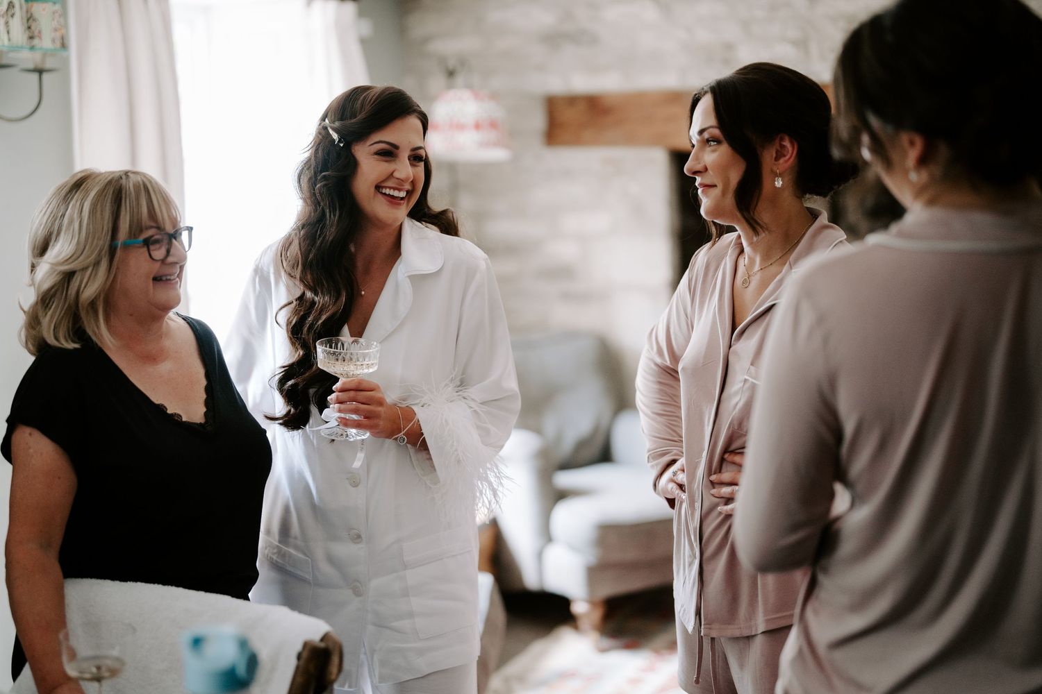 bride and bridesmaids laughing during bridal preparation at new inn cirencester