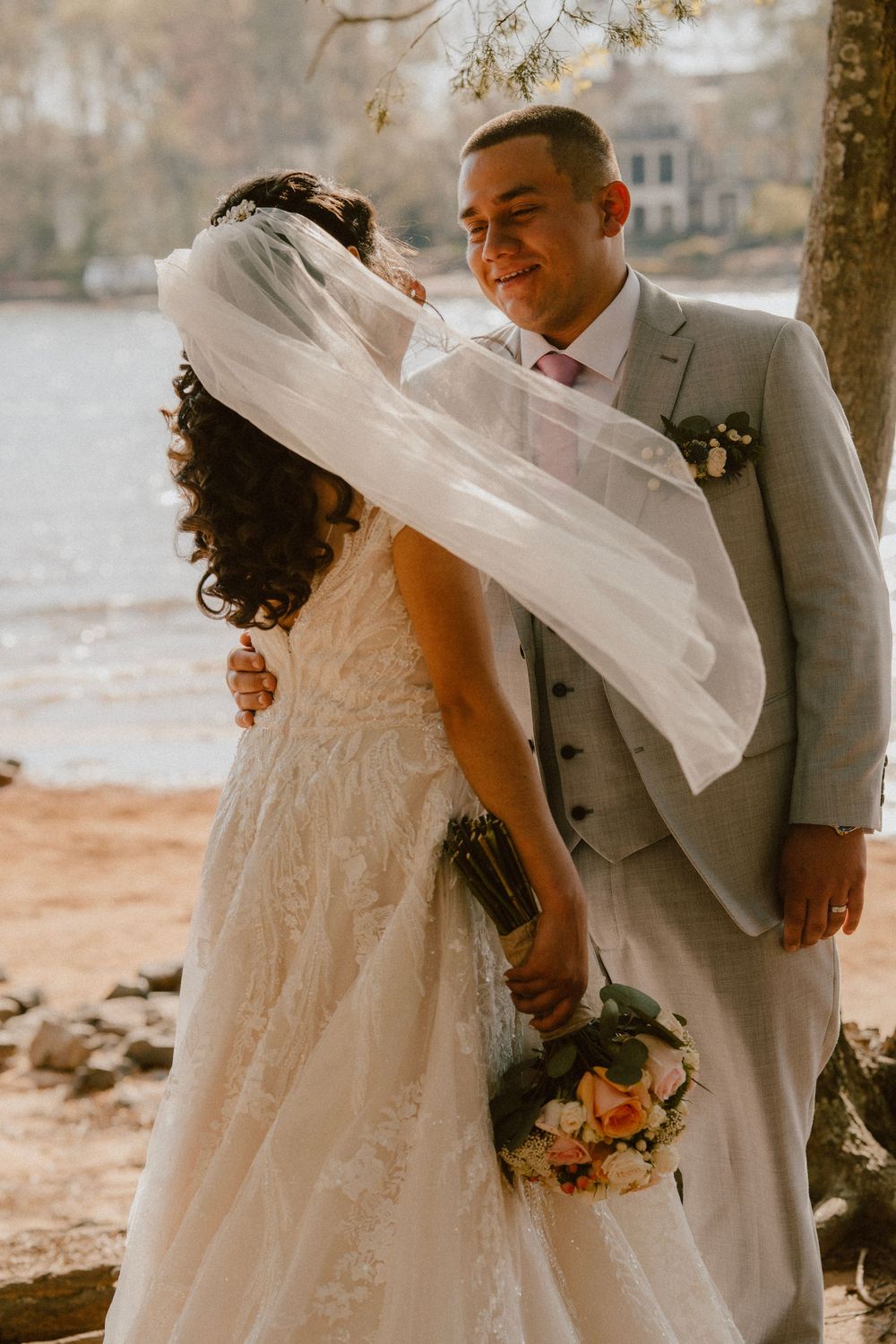 Romantic wedding portrait with flowing veil in autumn outdoor setting.
