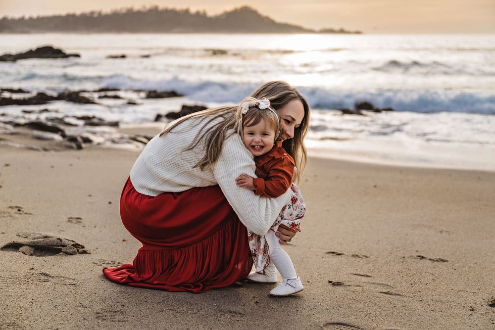Sunset beach photos showing intimate moments between family members on the sandy shoreline.