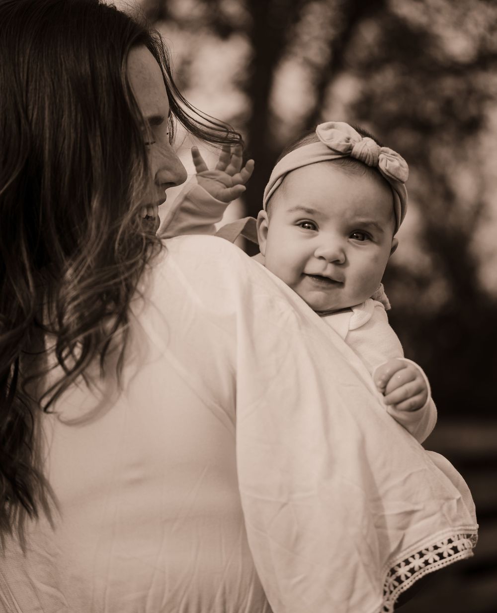 Black and white series capturing intimate moments between parent and child in matching white outfits.