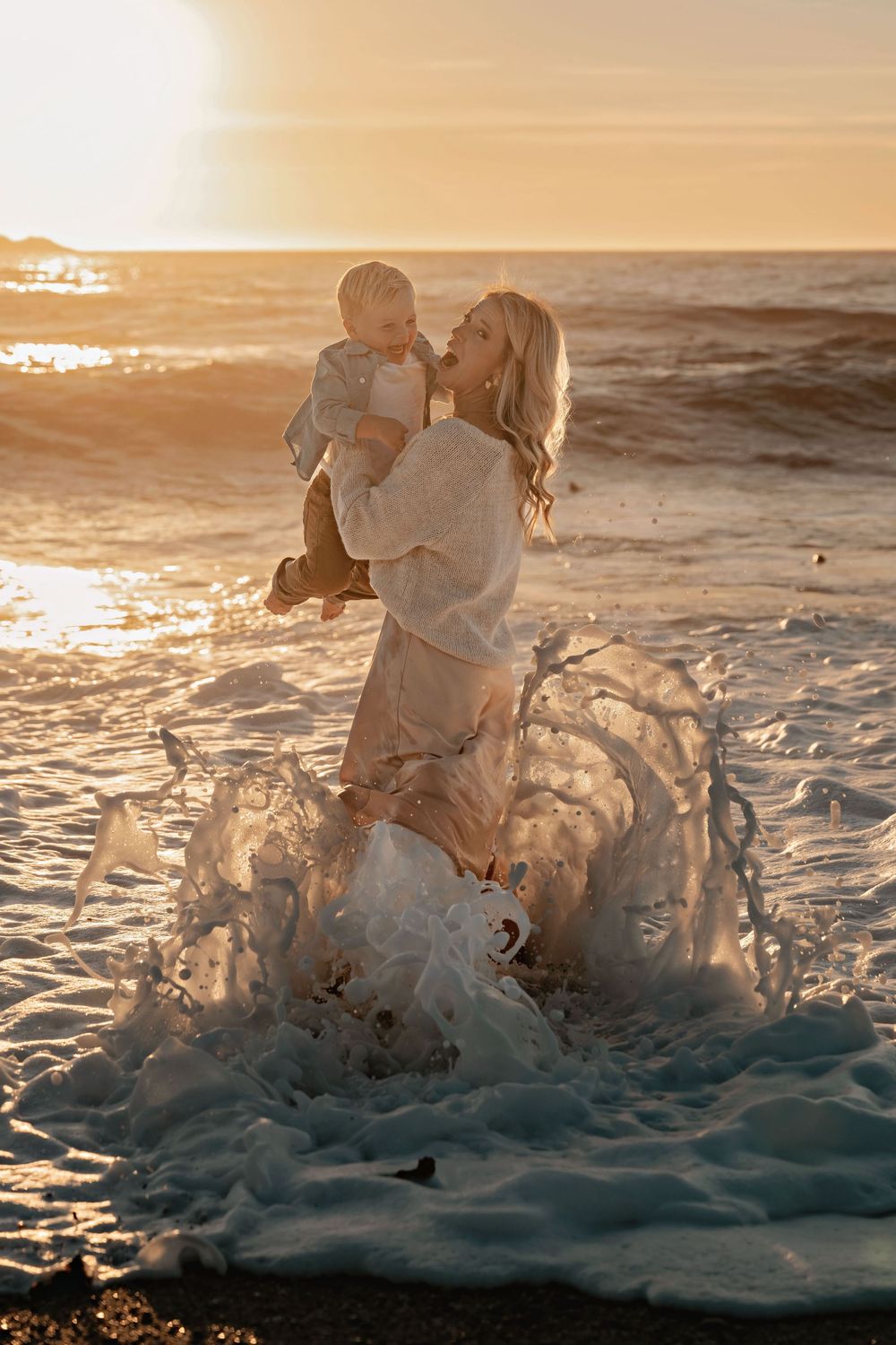 Ocean waves crash and splash against the shore during a golden sunset creating dramatic water formations.