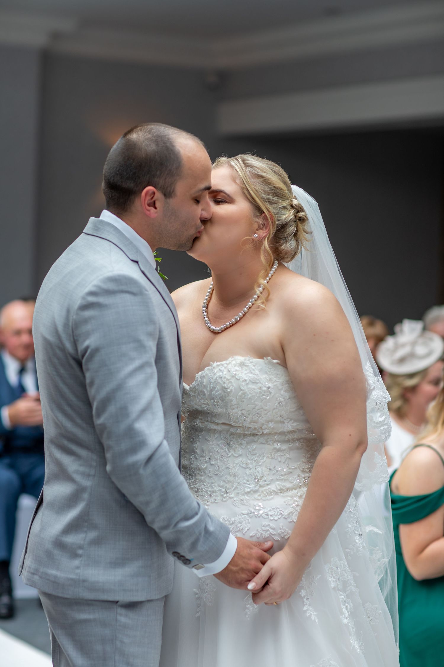 Newlywed couple shares romantic kisses during their wedding celebration.