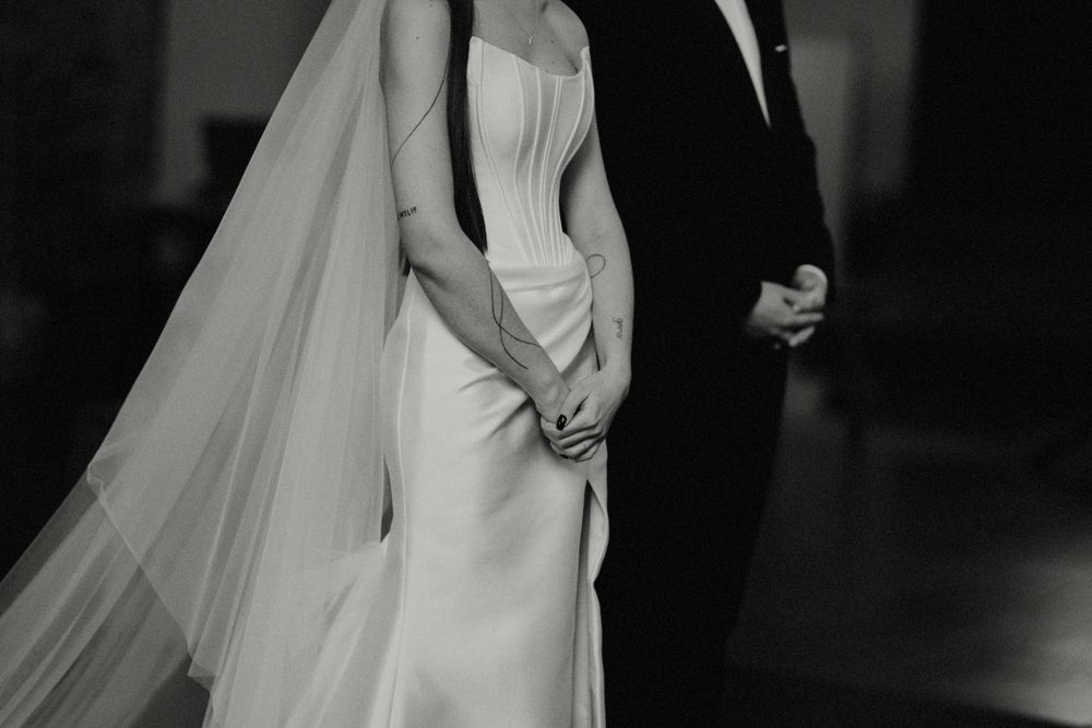 Black and white artistic shot of a bride and groom during their wedding ceremony.