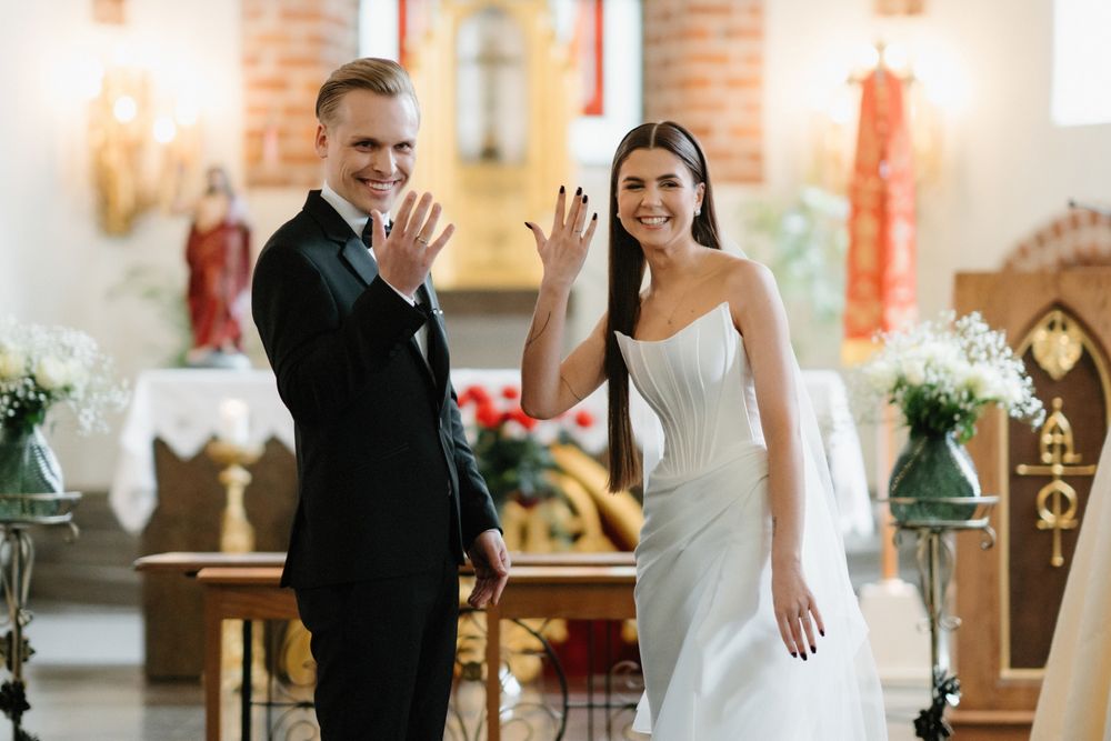 Joyful wedding moments captured in a sunlit church with brick and white architectural details.