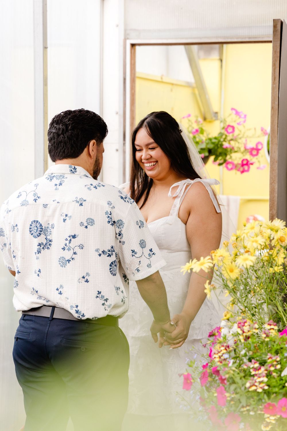 A loving couple share a tender moment surrounded by colorful flowers in a garden setting.