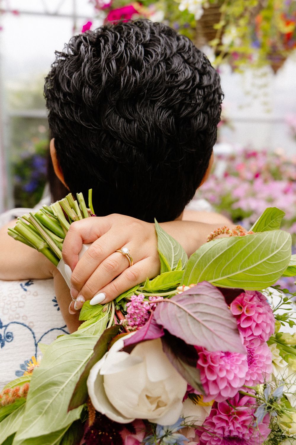 A sequence of close-up shots showing a florist making final adjustments to a pink and white floral arrangement.