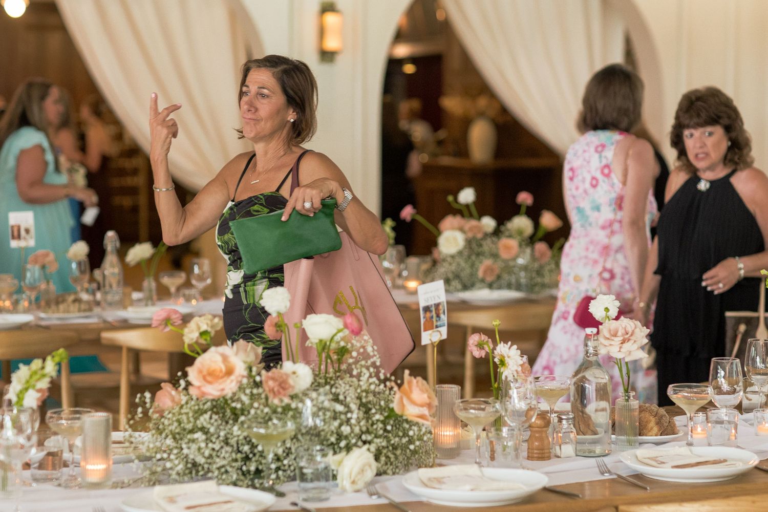 Wedding reception table settings with eucalyptus greenery and candlelight decor at an elegant indoor venue.