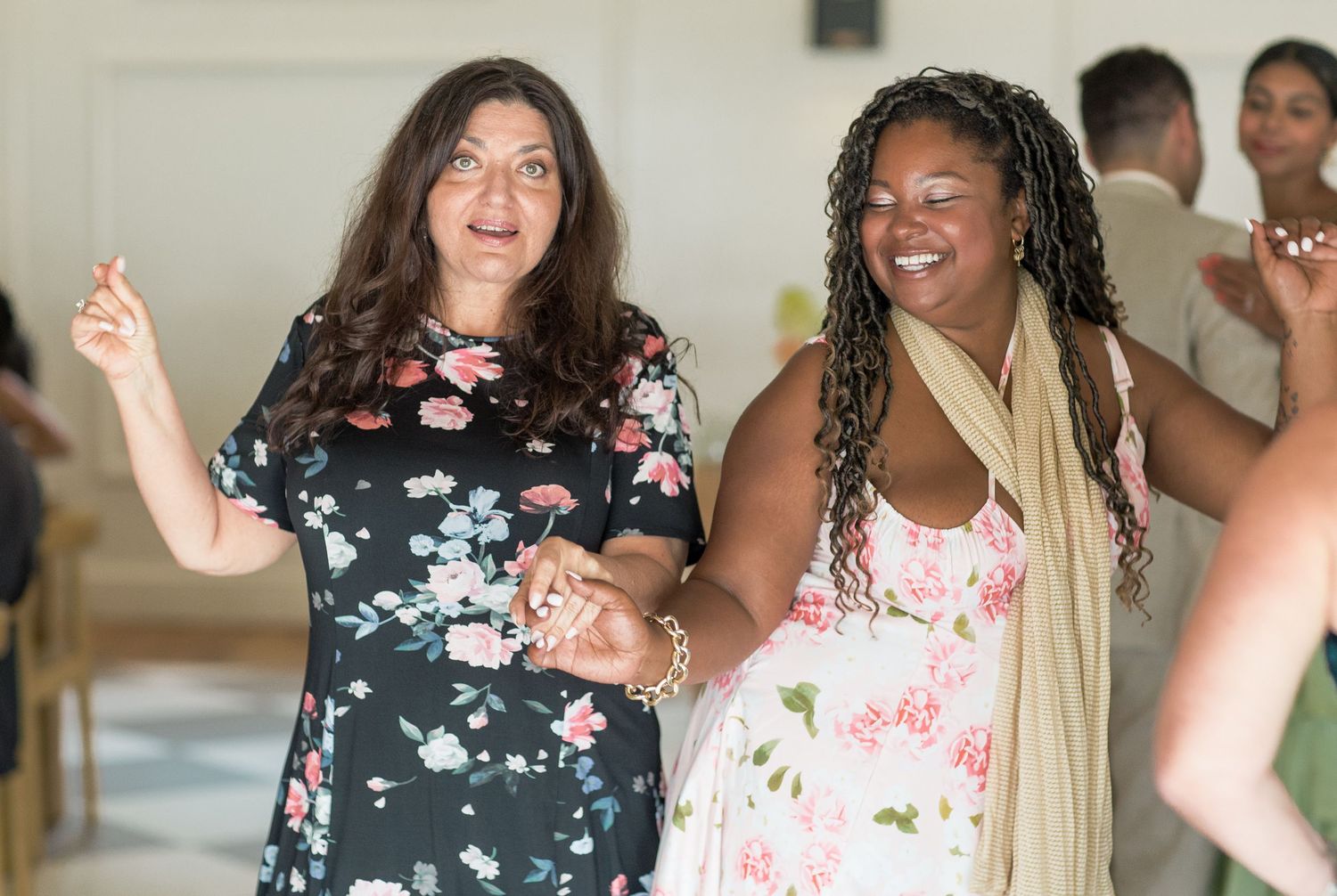 A group of people wearing floral dresses and casual attire gather together at what appears to be a social event.