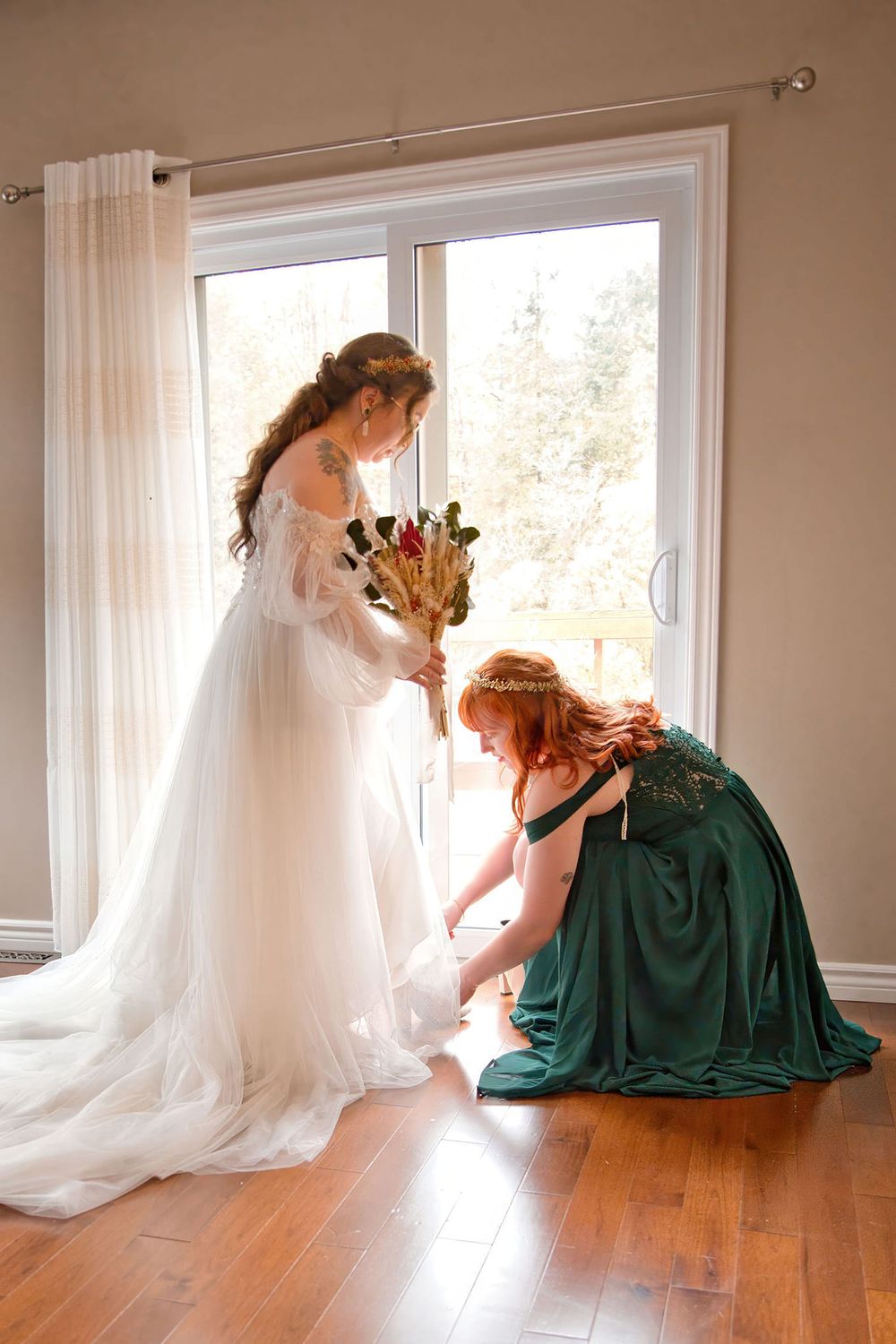 A series of connecting images showing two people in white and emerald green dresses near bright windows on hardwood floors.
